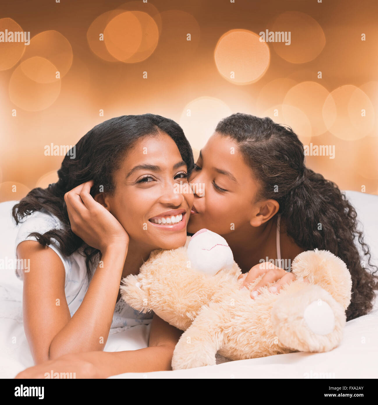Composite image of pretty woman lying on bed with her daughter kissing