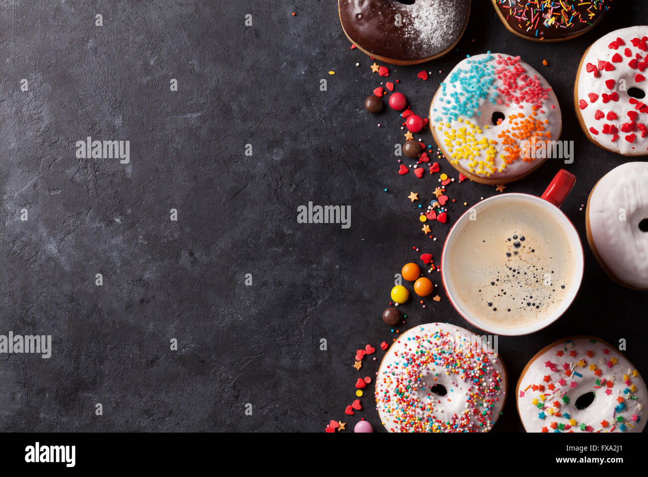 Colorful donuts and coffee on stone table. Top view with copy space ...