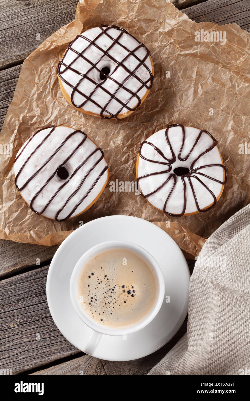 Donuts and coffee on wooden table. Top view Stock Photo - Alamy
