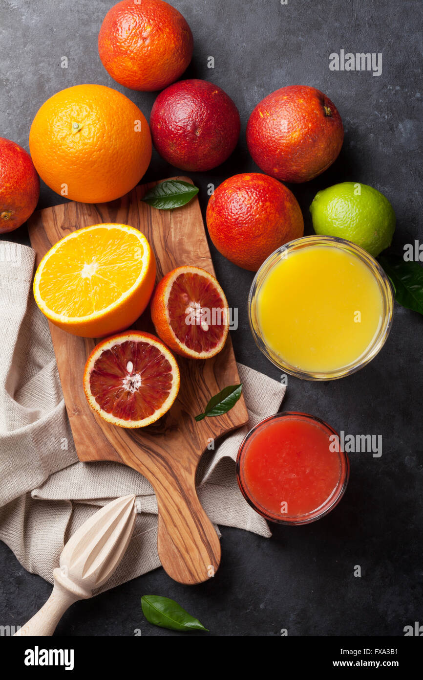 Fresh citruses and juice on dark stone background. Oranges and limes. Top view Stock Photo