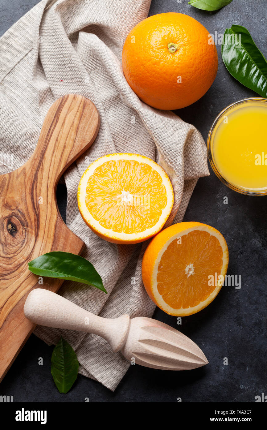 Fresh orange fruits and juice on stone table. Top view Stock Photo