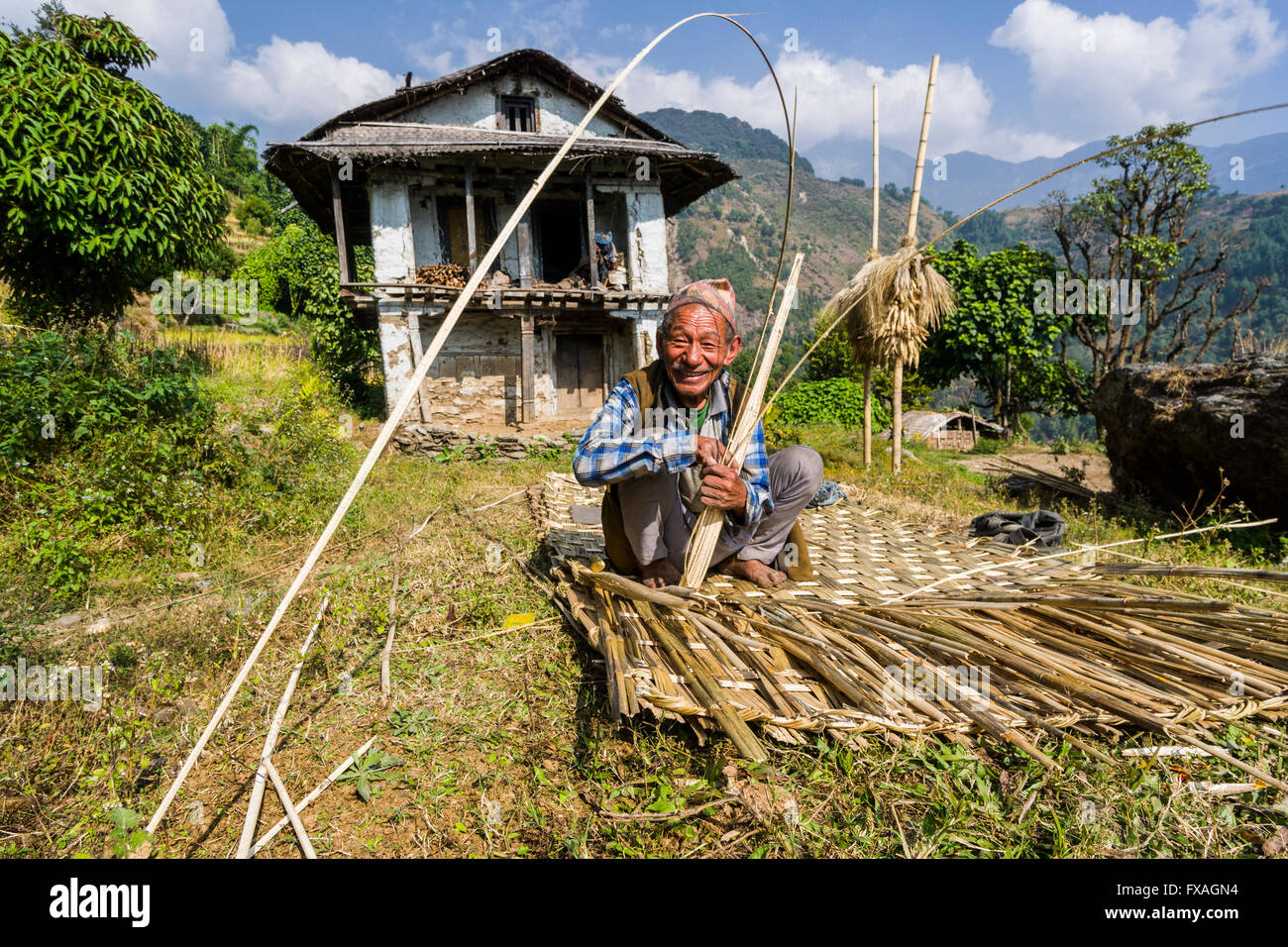 Man building a woven bamboo fence to be used as a wall in front of his farmers house, Bung, Solo Khumbu, Nepal Stock Photo