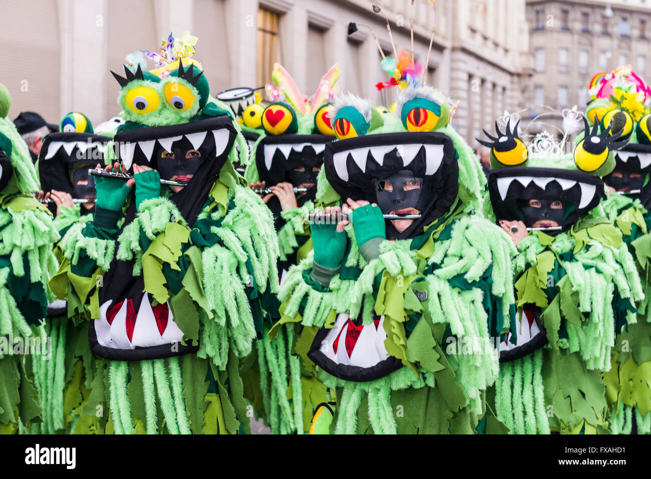 Members of the Gugge marching brass bands wearing fancy dresses and masks at the great procession at the Carnival of Basel Stock Photo