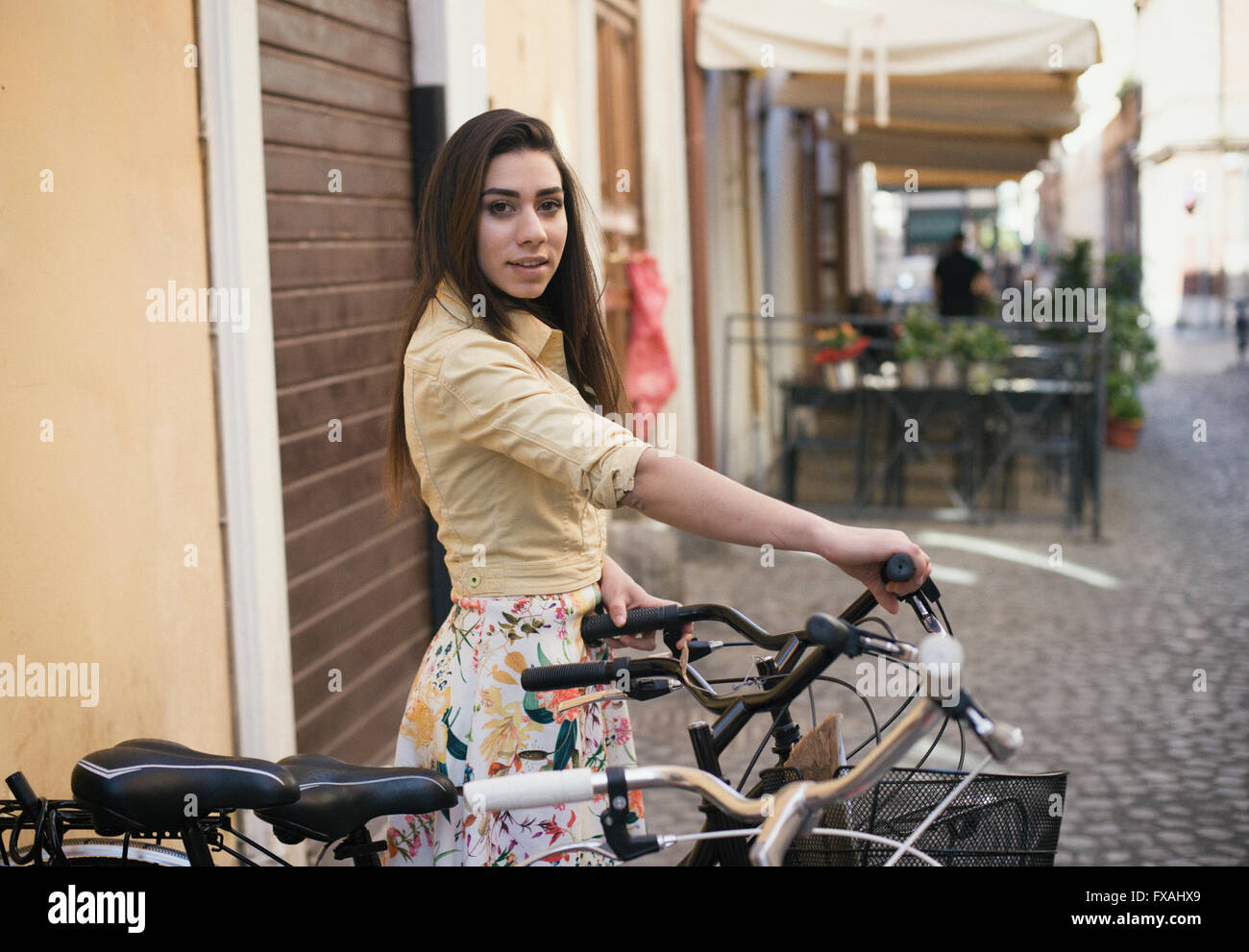Young pretty woman ready for a bicycle ride in the city street, summer colors sunlight Stock Photo
