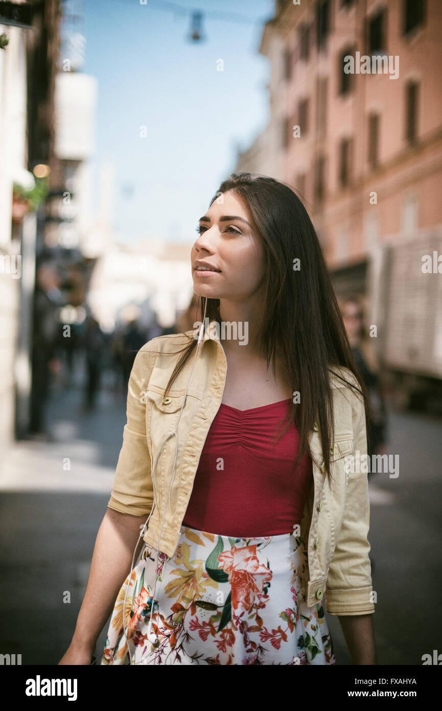 Young pretty woman walking in the city in summer smiling and looking out Stock Photo