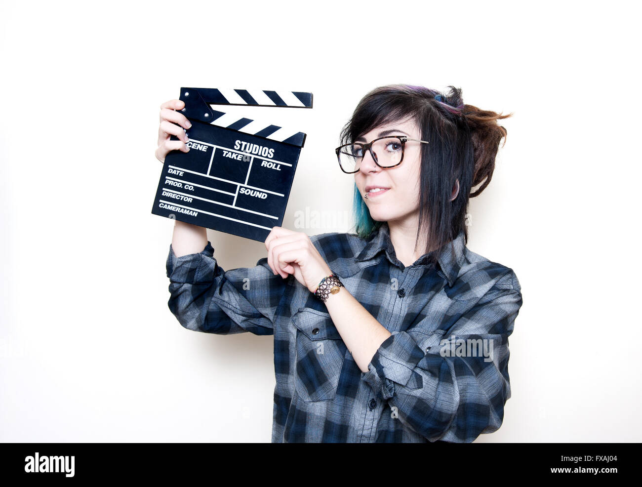 Smiling teen woman portrait showing movie clapper board on white background Stock Photo