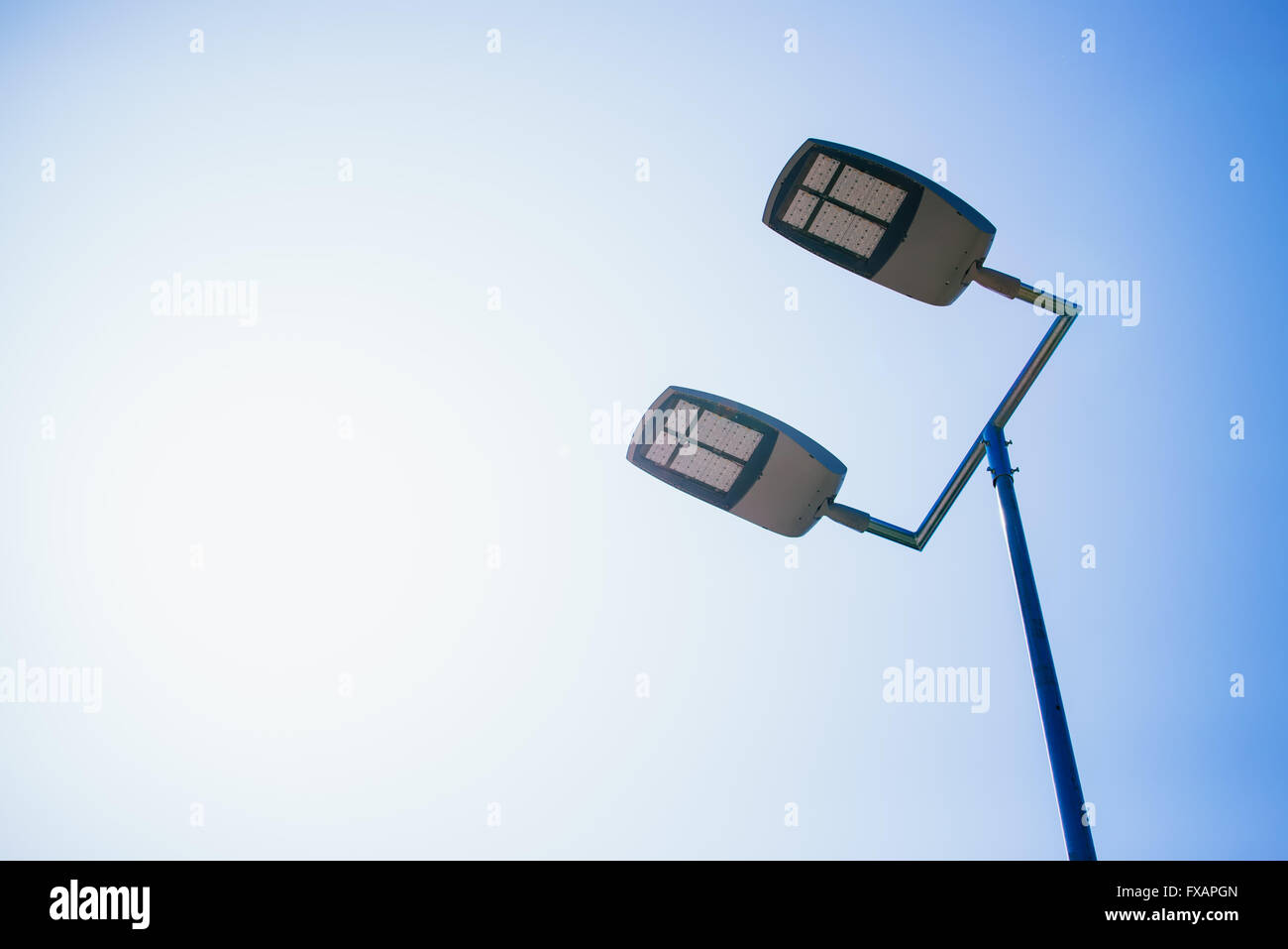 Outdoor basketball court led lighting equipment against clear blue sky. Stock Photo