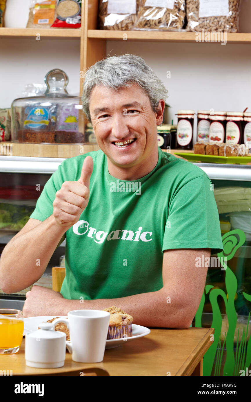 Elderly happy man in organic café holding his thumbs up Stock Photo - Alamy