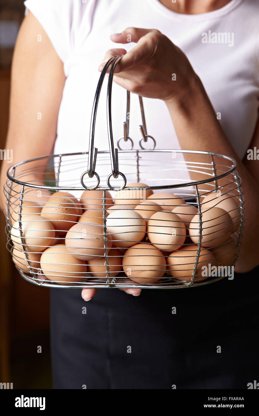 Woman carrying big basket of free range organic eggs Stock Photo