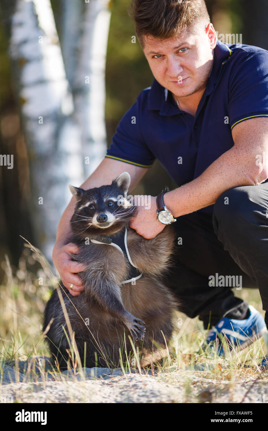 Portrait of a man with raccoon in a forest Stock Photo