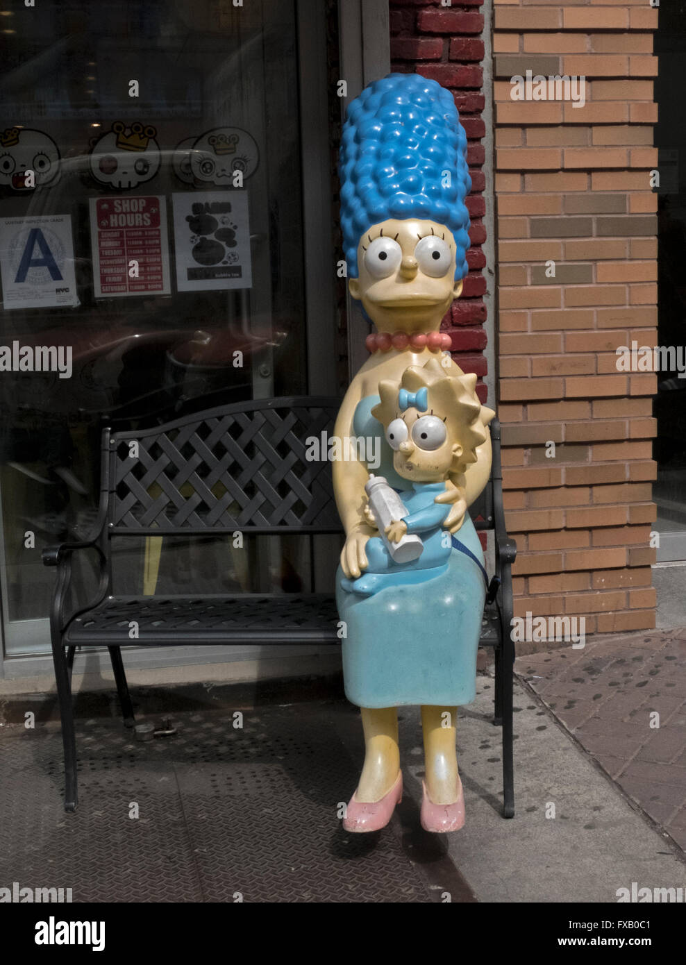 A statue of Marge Simpson holding baby Maggie on a bench outside of Vivi Bubble Tea on Hester Street in lower Manhattan. Stock Photo
