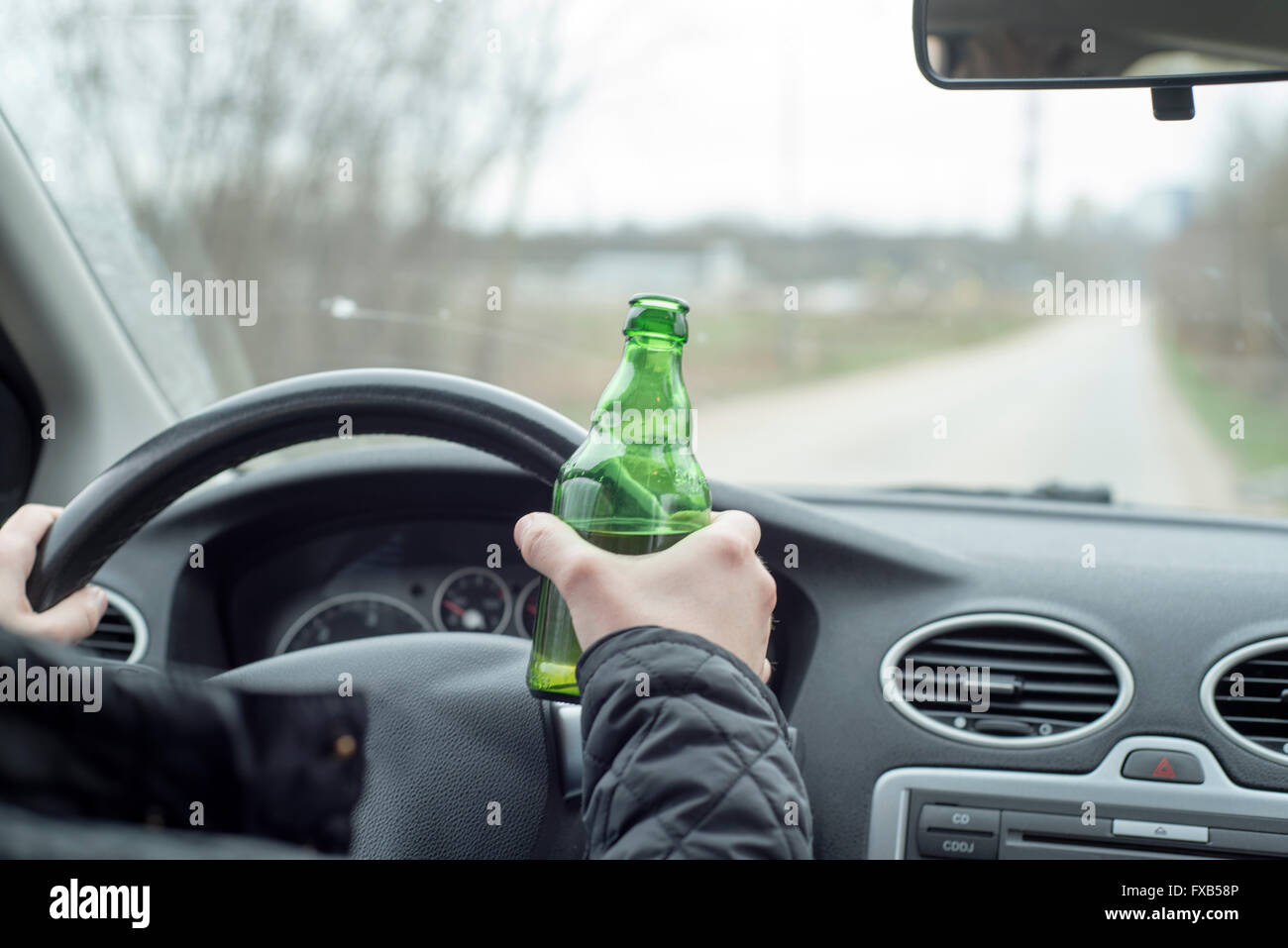 a picture of a young man drinking alcohol while driving Stock Photo - Alamy