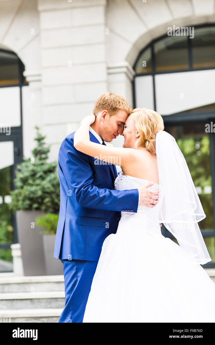 Handsome groom kissing beautiful bride outdoors Stock Photo - Alamy