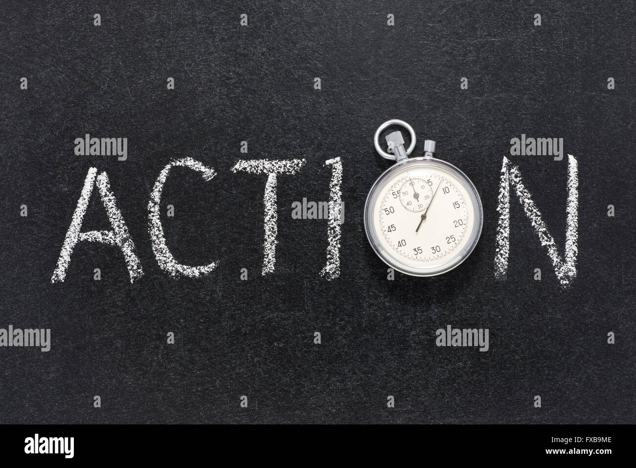 action word handwritten on chalkboard with vintage precise stopwatch used instead of O Stock Photo