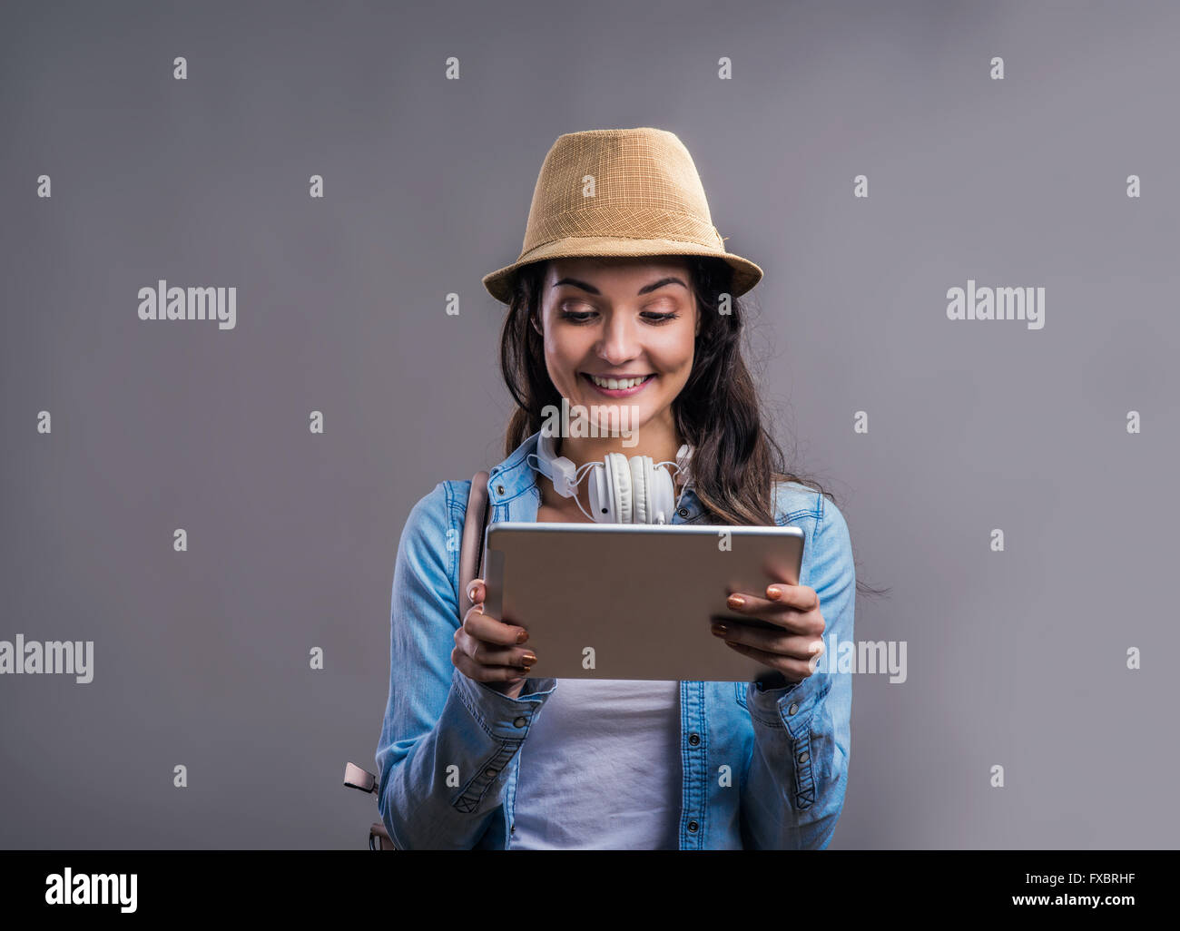 Tourist girl in denim shirt with tablet, studio shot Stock Photo