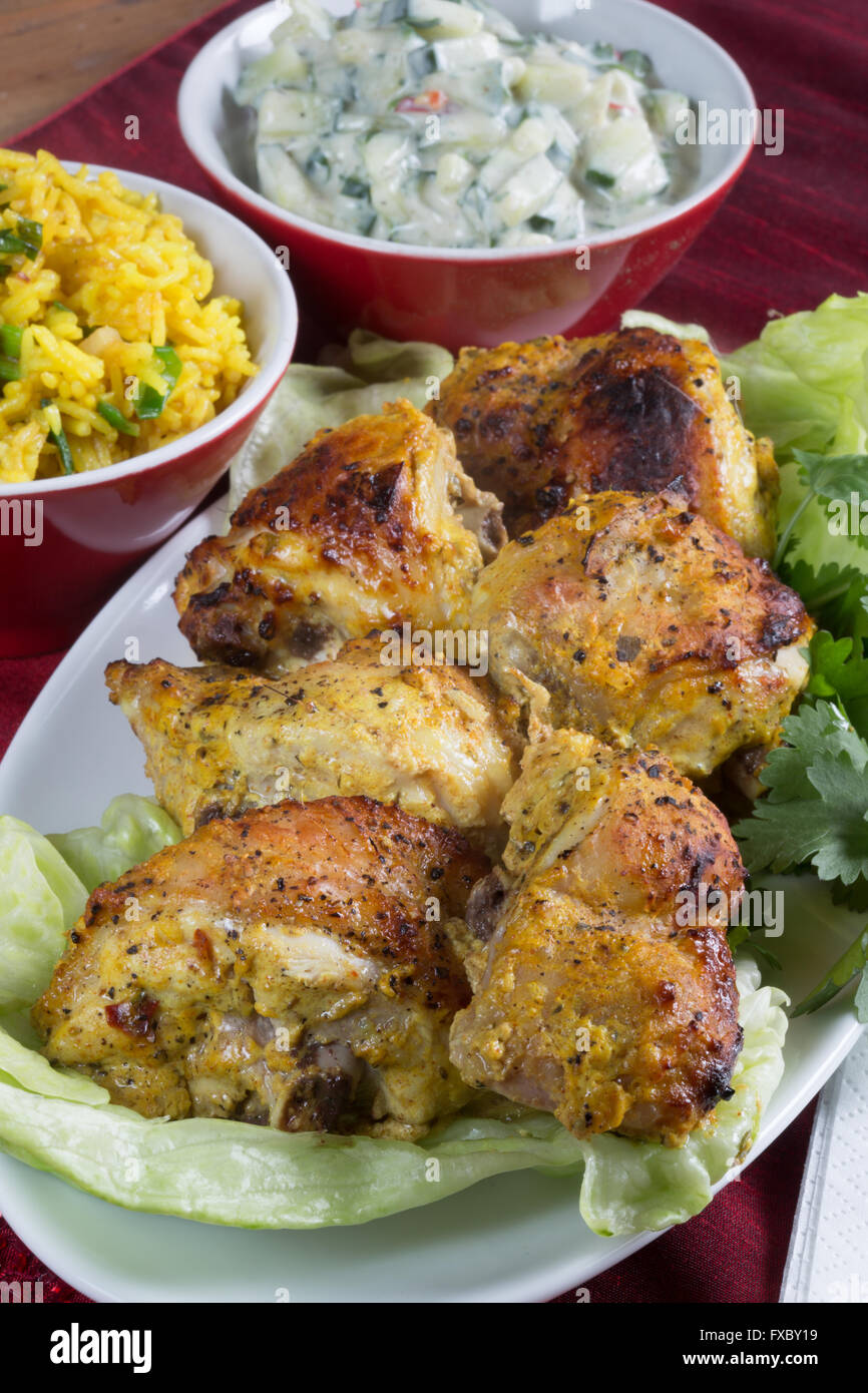 A homemade portion of Indian style Chicken Tandoori with Safron Rice and Cucumber Riata. Stock Photo