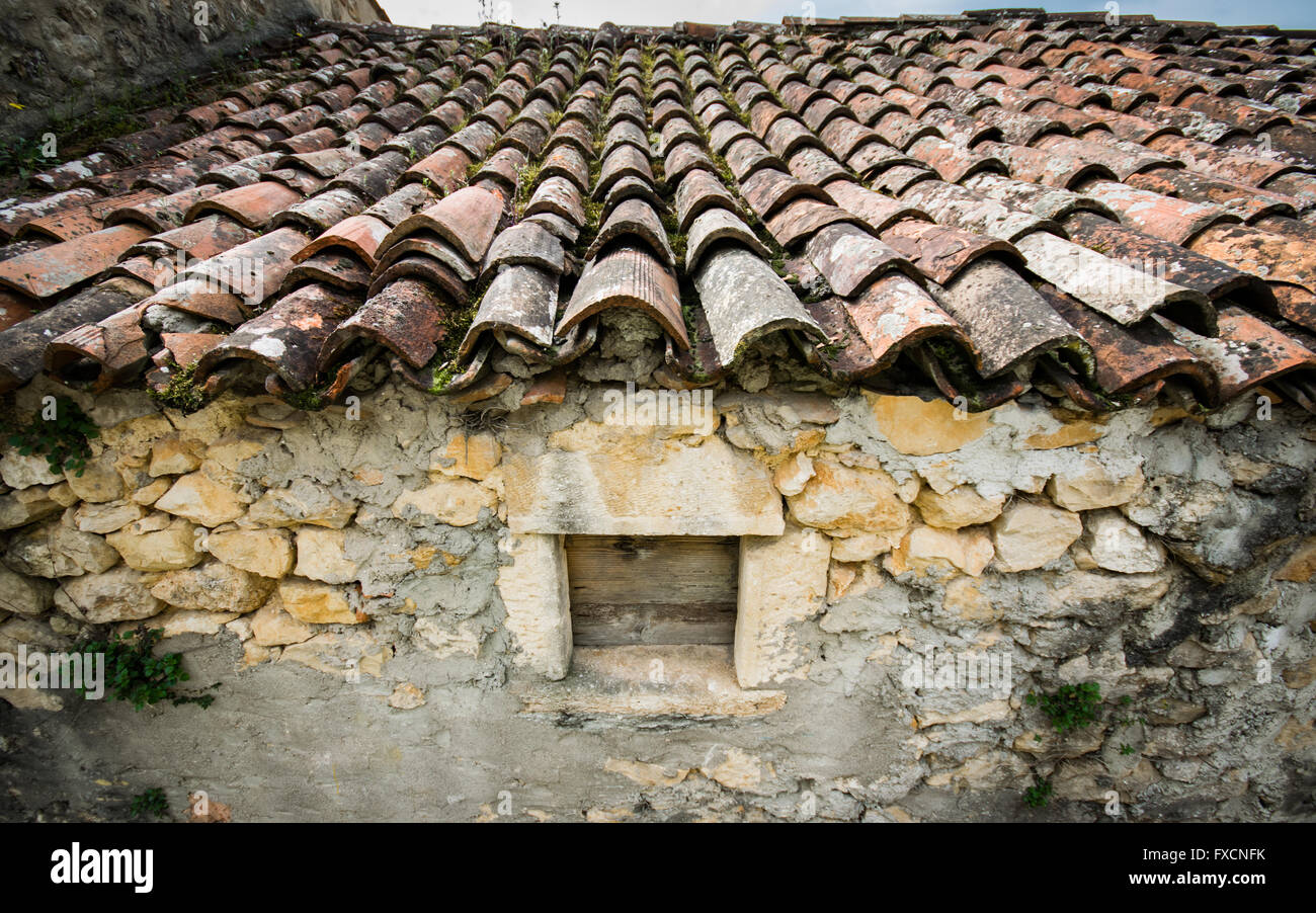 Old red roof tiles on a roof of an old cottage. Stock Photo