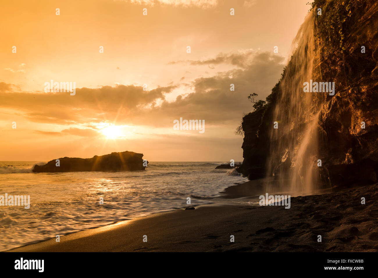 Sunset At Melasti Beach With A Waterfall Near The Tanah Lot
