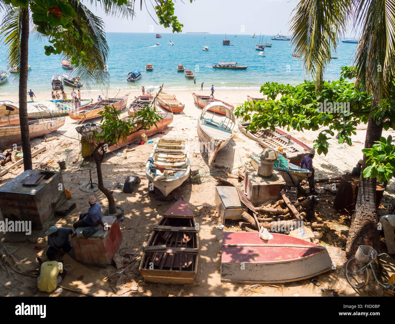 Local people with their boats on the seashore in Stone Town, Zanzibar. Stock Photo