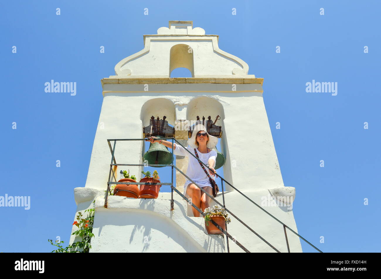 girl standing beneath a small church belfry Stock Photo