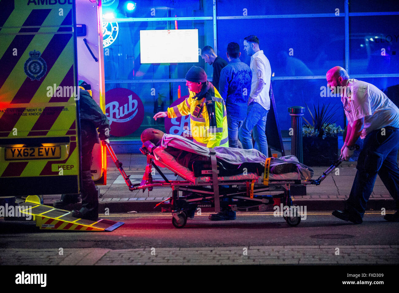 A man is treated by paramedics on Broad Street in Birmingham on a Saturday night. Stock Photo