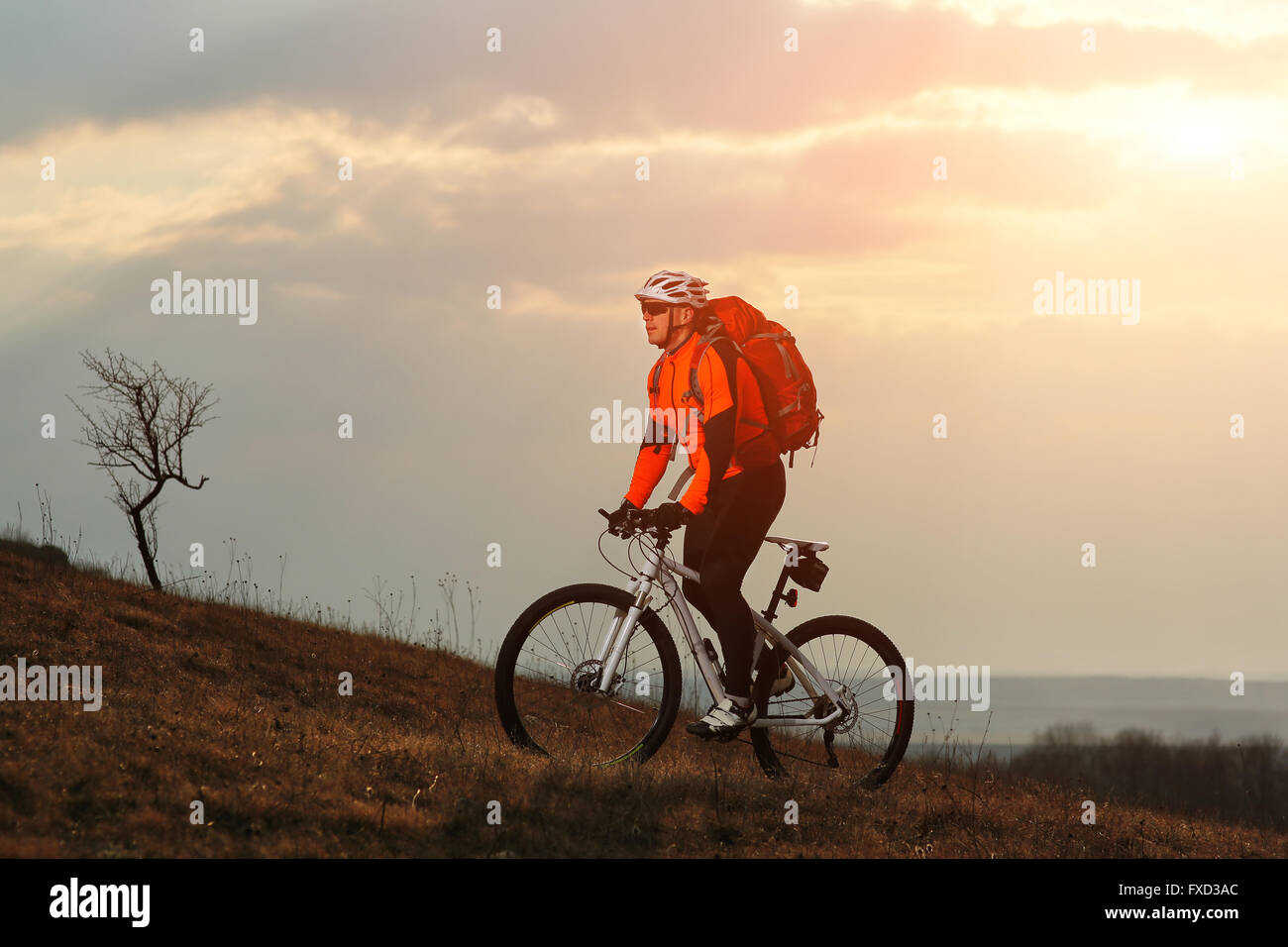 Man cyclist with backpack riding the bicycle Stock Photo - Alamy