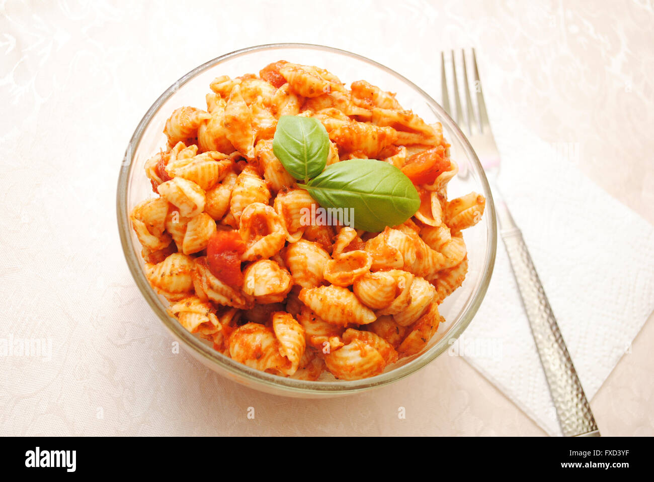 A Glass Bowl Filled with Shell Pasta with Tomato Sauce Stock Photo