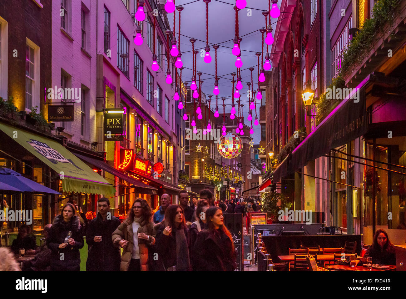Giant illuminated purple light bulbs hanging from wires above  Ganton St in Soho, London, UK Stock Photo