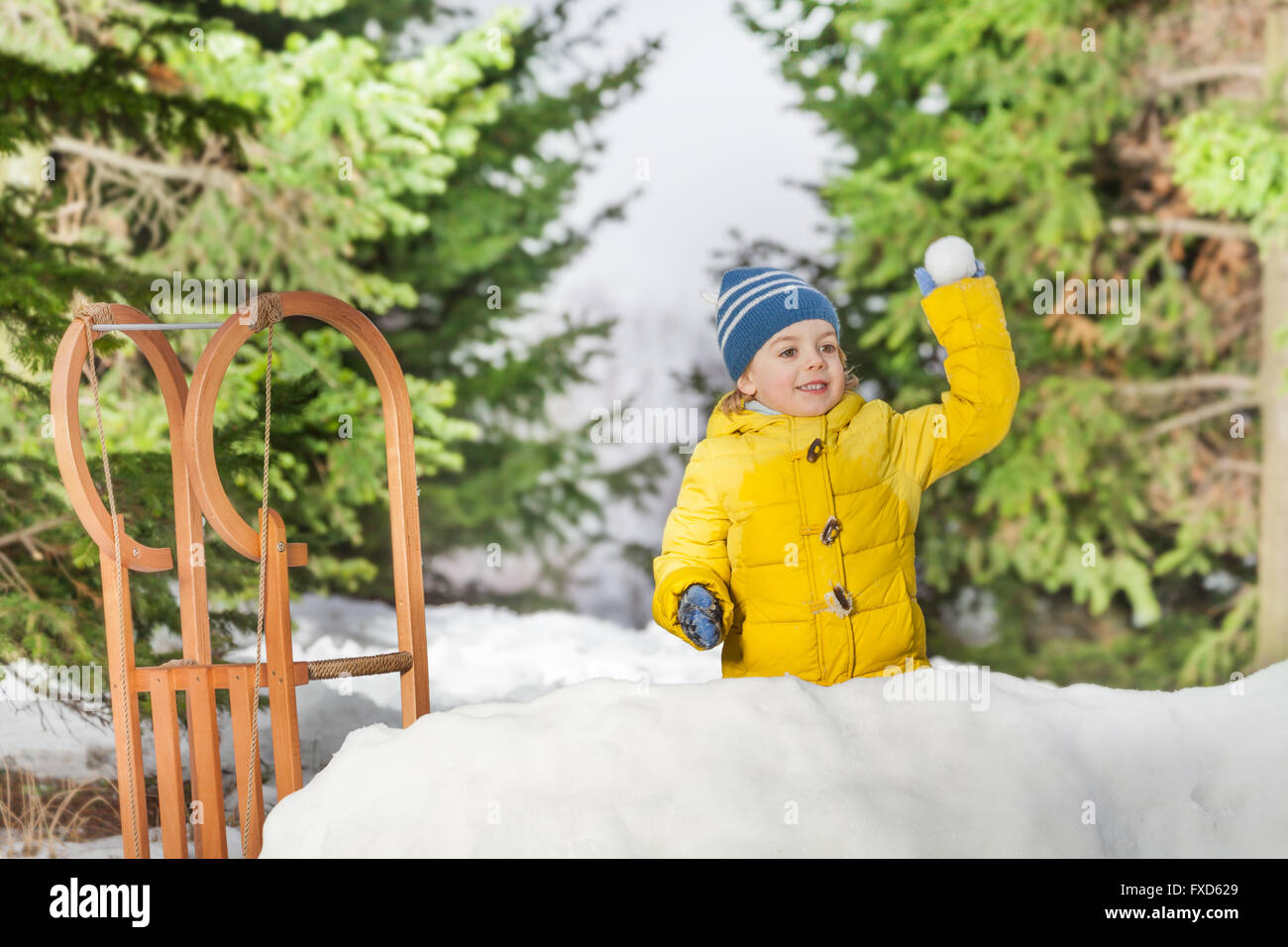 Little boy in snow fortress play snowball fight Stock Photo