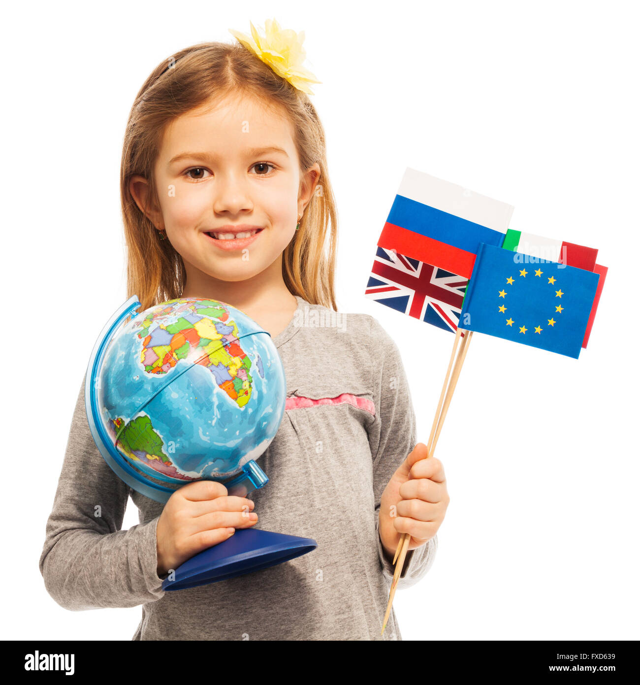 Schoolgirl holding a globe and different flags Stock Photo