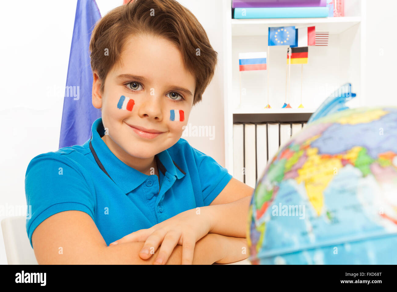 Cute French boy learning geography with the globe Stock Photo