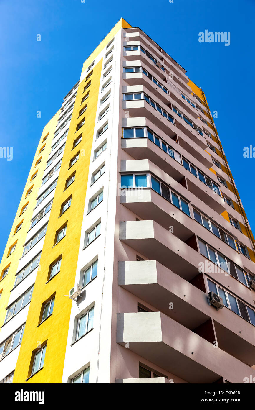 New tall apartment building against blue sky background Stock Photo - Alamy