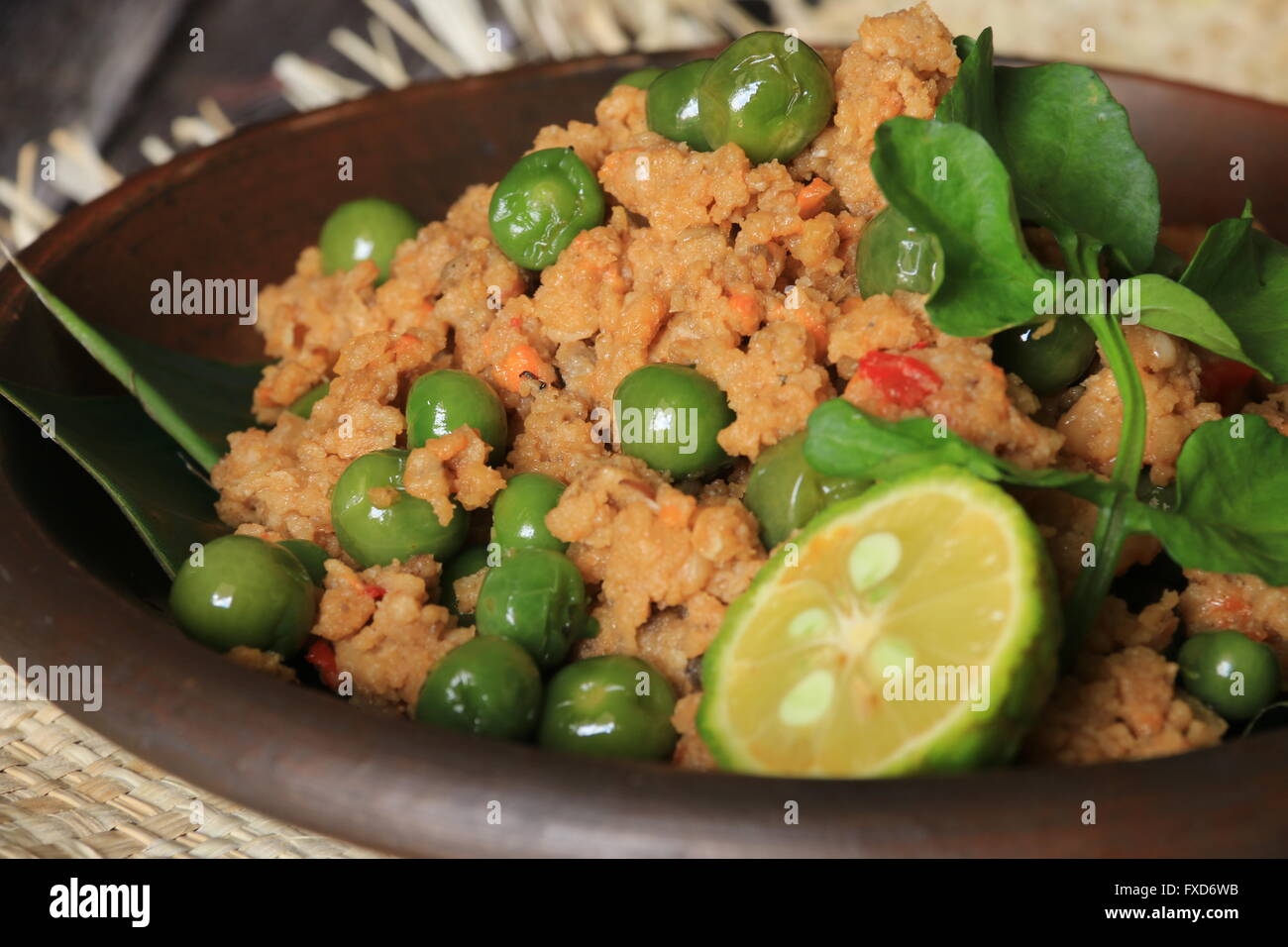 Popular Sundanese vegetarian dish of sauteed oncom and leunca, served on traditional earthenware plate. Stock Photo