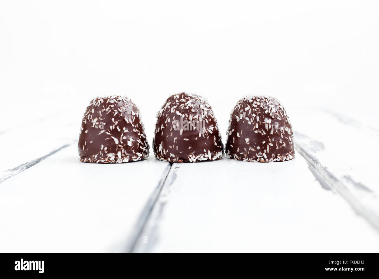 chocolate coated snowballs on white wooden Stock Photo