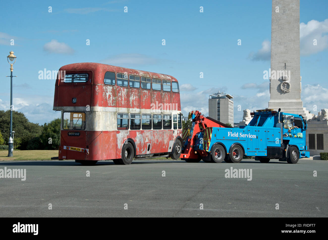 Old derelict red bus being towed. Stock Photo