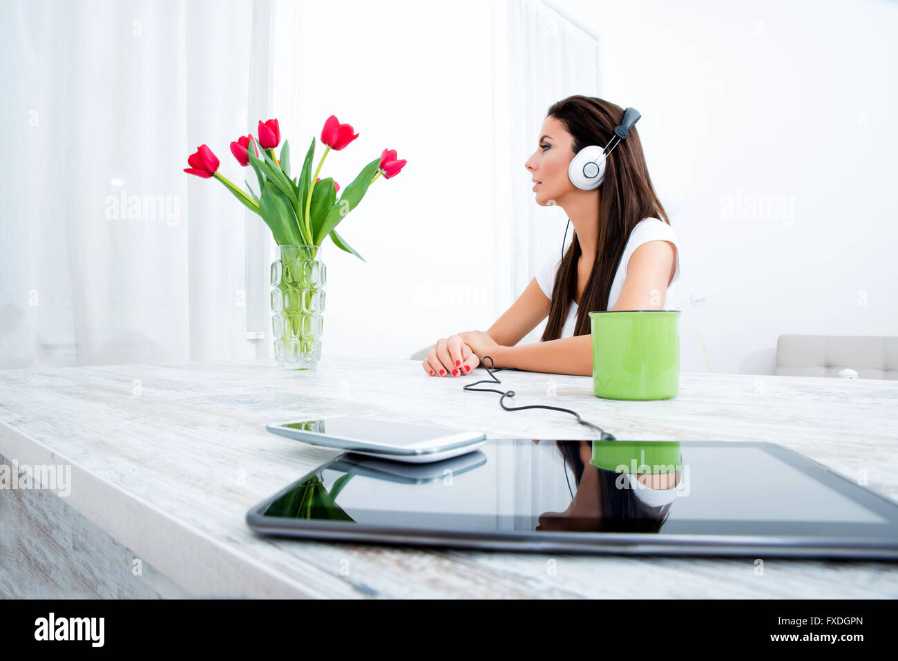 Portrait of a young beautiful woman listening to music with headphones ...