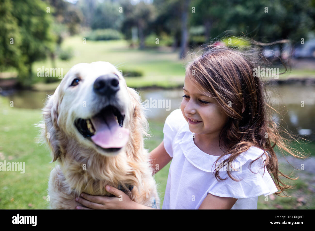 Smiling girl with her pet dog in the park Stock Photo - Alamy