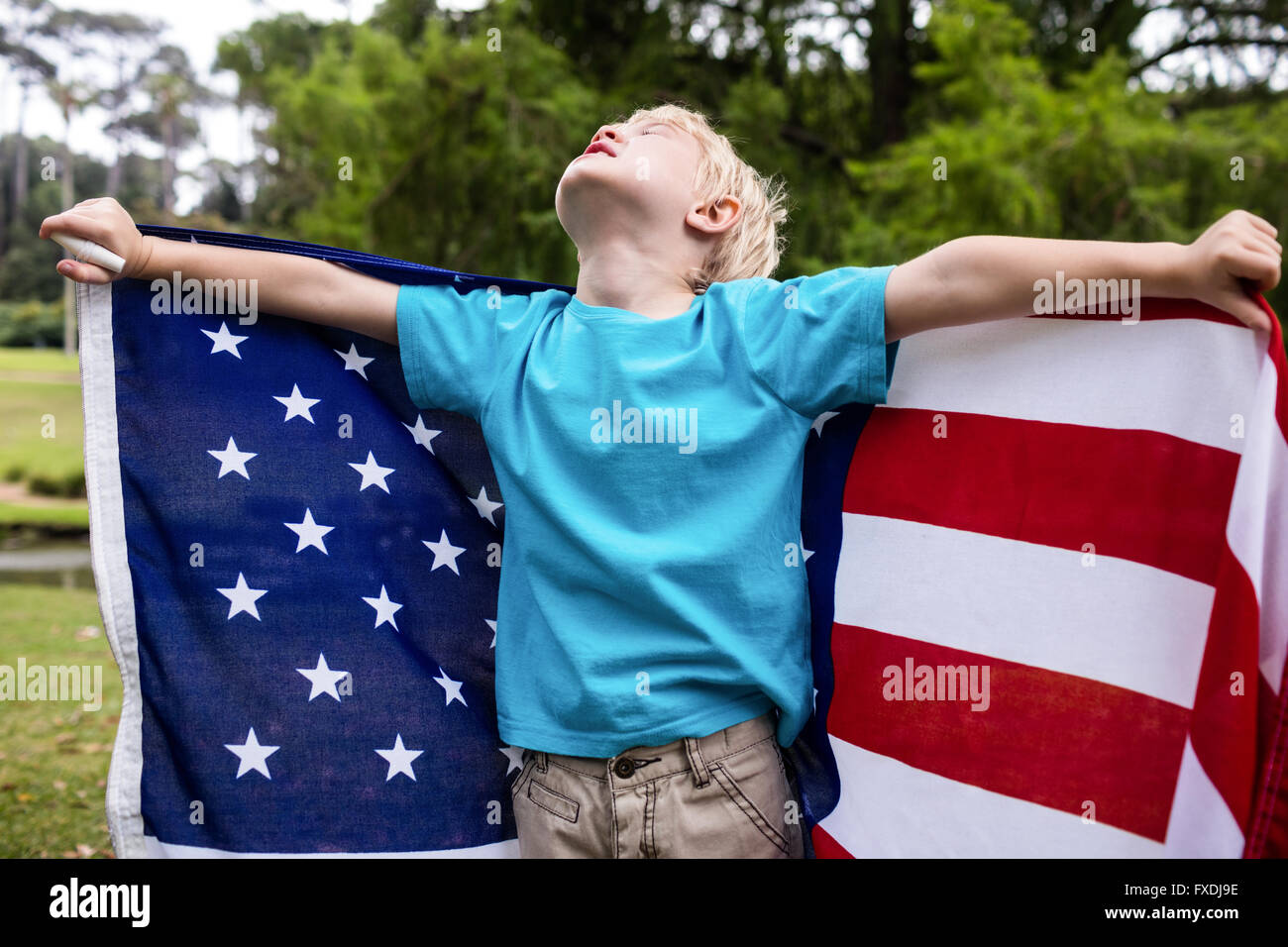 Boy holding an american flag in the park Stock Photo