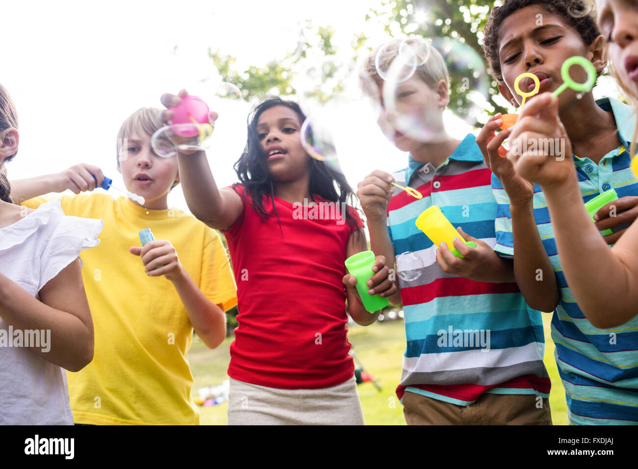 Children blowing bubbles wand in the park Stock Photo