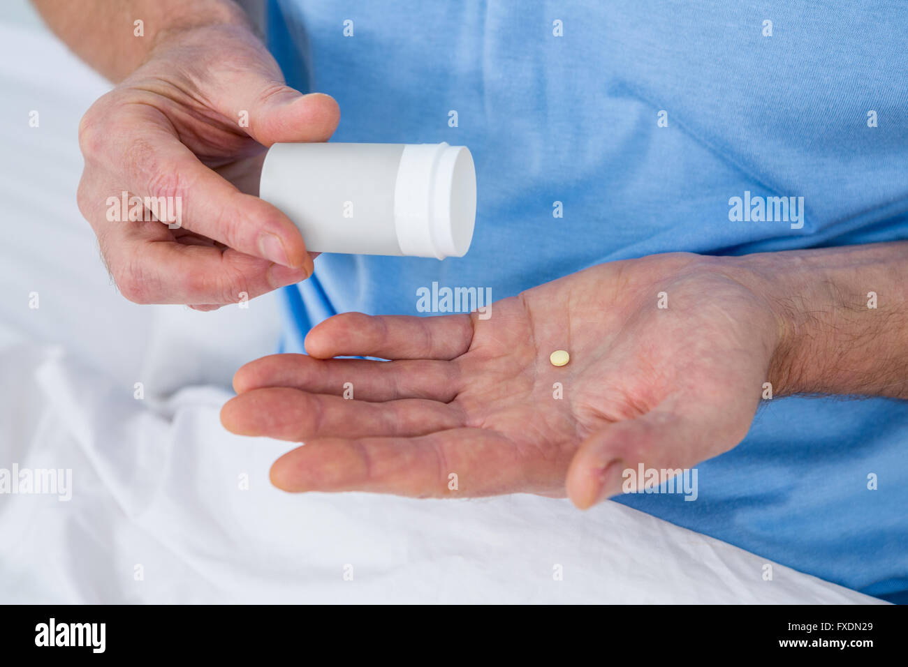 Midsection of man taking pill Stock Photo