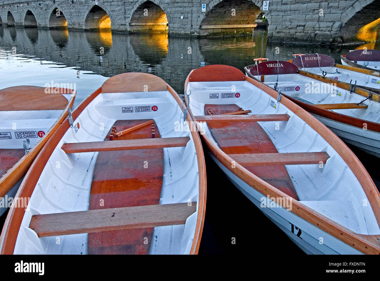 White day hire boats on the River Avon at Stratford upon Avon, Warwickshire with the stone arched Clopton Bridge in the background. Stock Photo