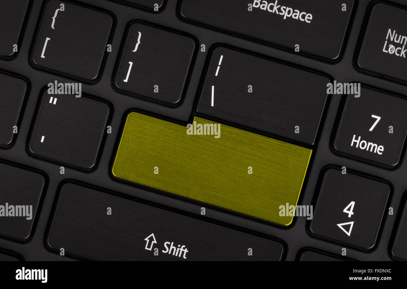 Laptop computer keyboard with blank yellow button for text Stock Photo