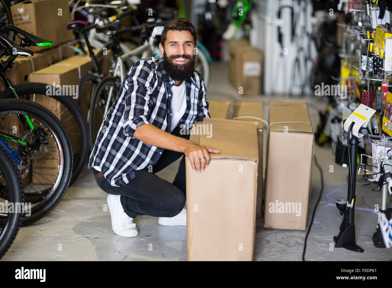 Casual hipster picking up box delivery in bike repair shop Stock Photo -  Alamy