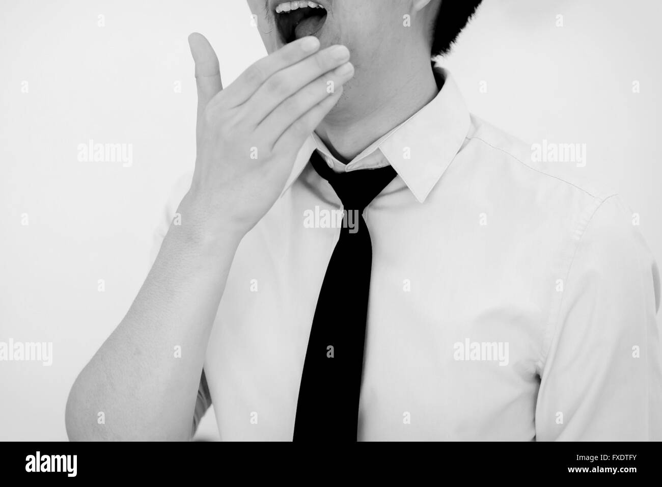 Yawning male office worker in white isolated background Stock Photo - Alamy