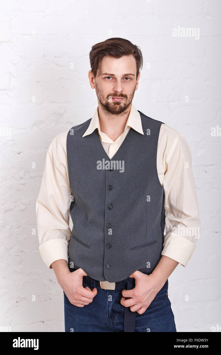 puppy hebzuchtig cafe Young romantic man in vest and jeans. Men's fashion. Man put his hands on  the belt Stock Photo - Alamy