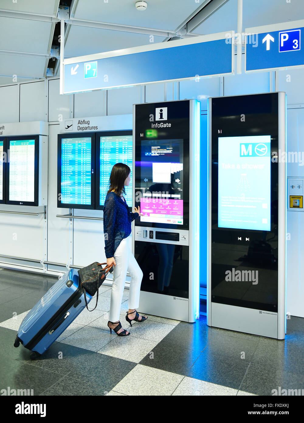 Woman with luggage at the InfoGate, information, Terminal 2, Munich Airport, Munich, Bavaria, Germany Stock Photo