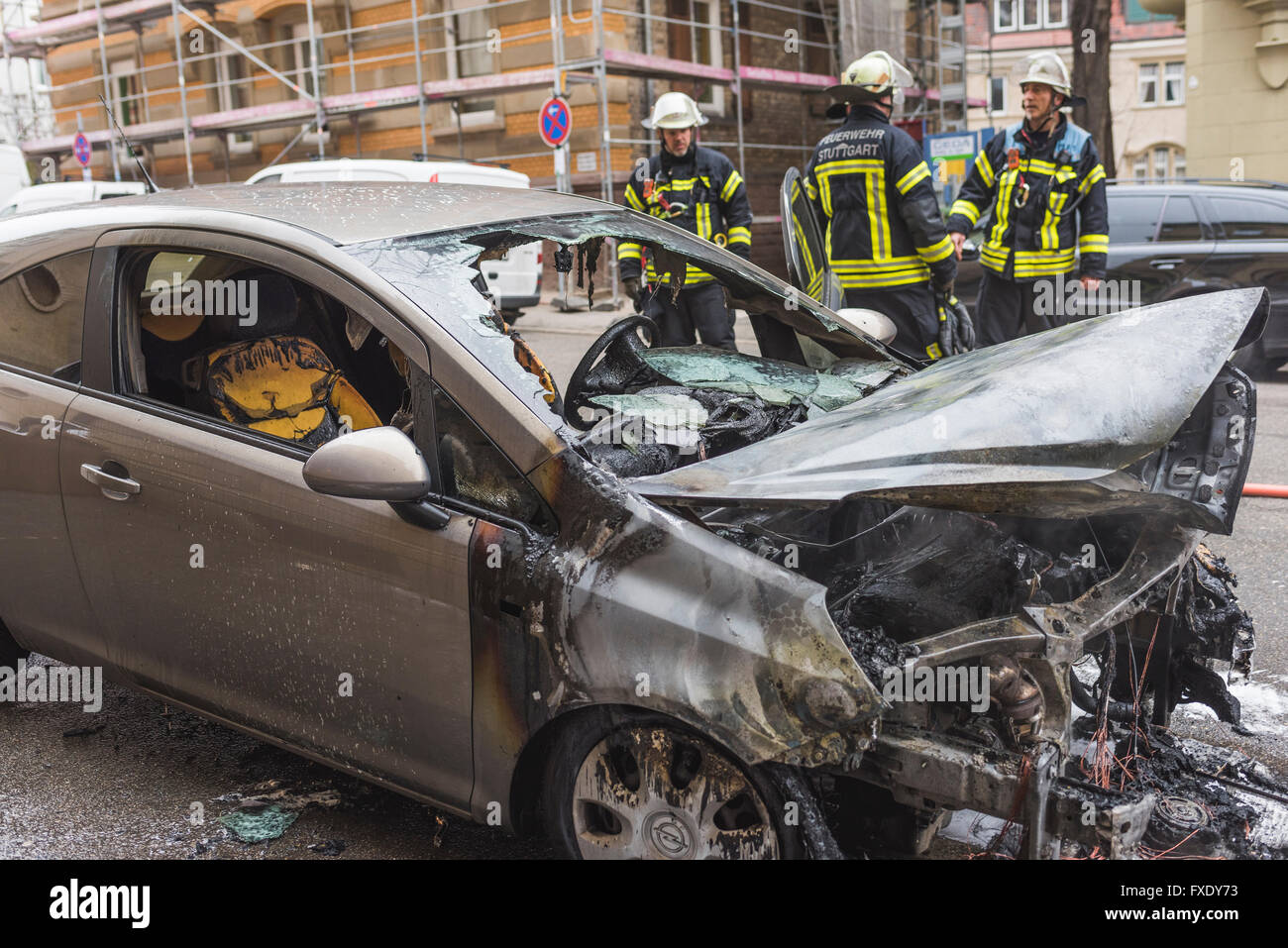 Fire department extinguishing a burning Corsa, burnt engine compartment