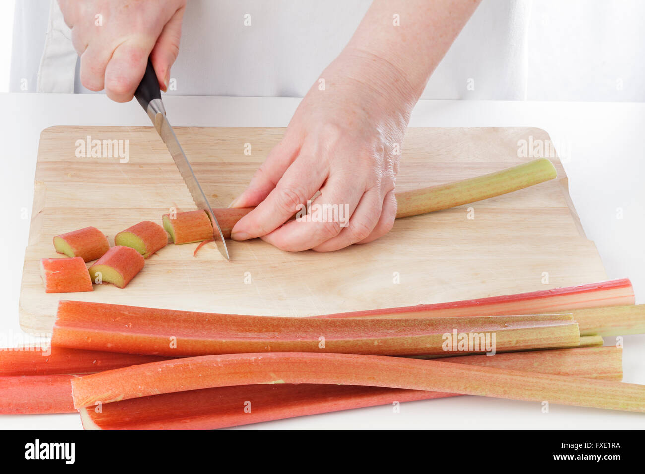 Hands cutting rhubarb in the kitchen Stock Photo