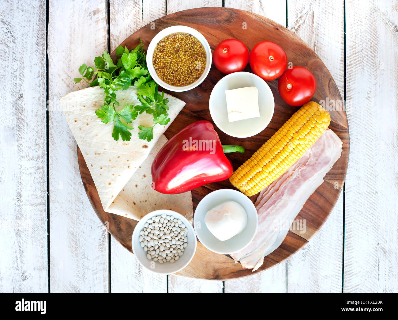 Ingredients for cooking Mexican Quesadilla wrap with vegetables, corn, sweet pepper and sauces on the parchment and table. horiz Stock Photo
