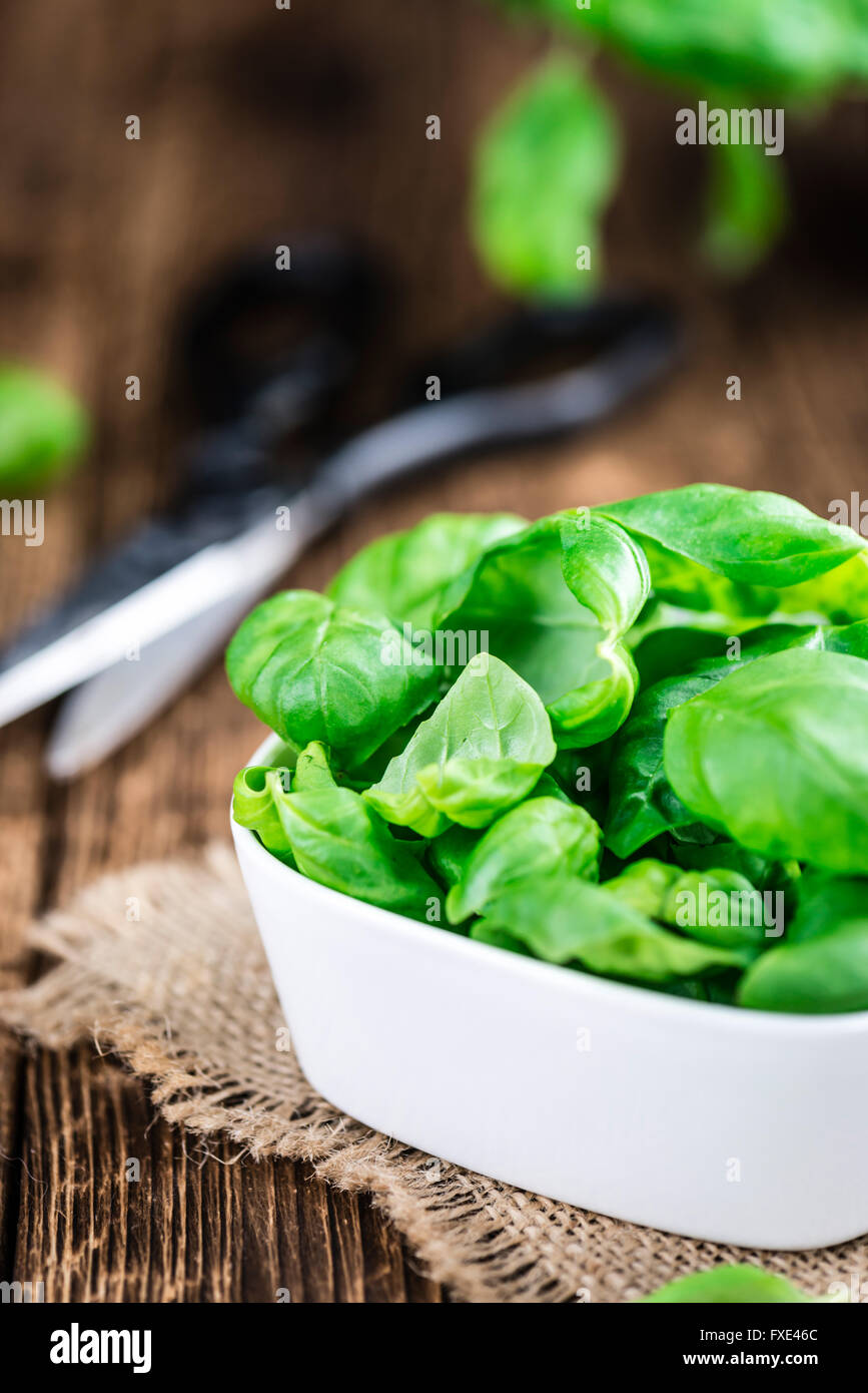 Heap of fresh Basil (selective focus) on an old wooden table (close-up shot) Stock Photo